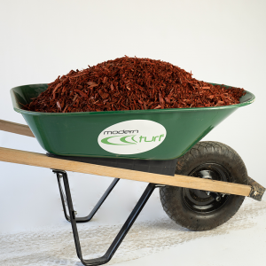 A green wheelbarrow filled with reddish-brown mulch, labeled modern turf, on a white background.