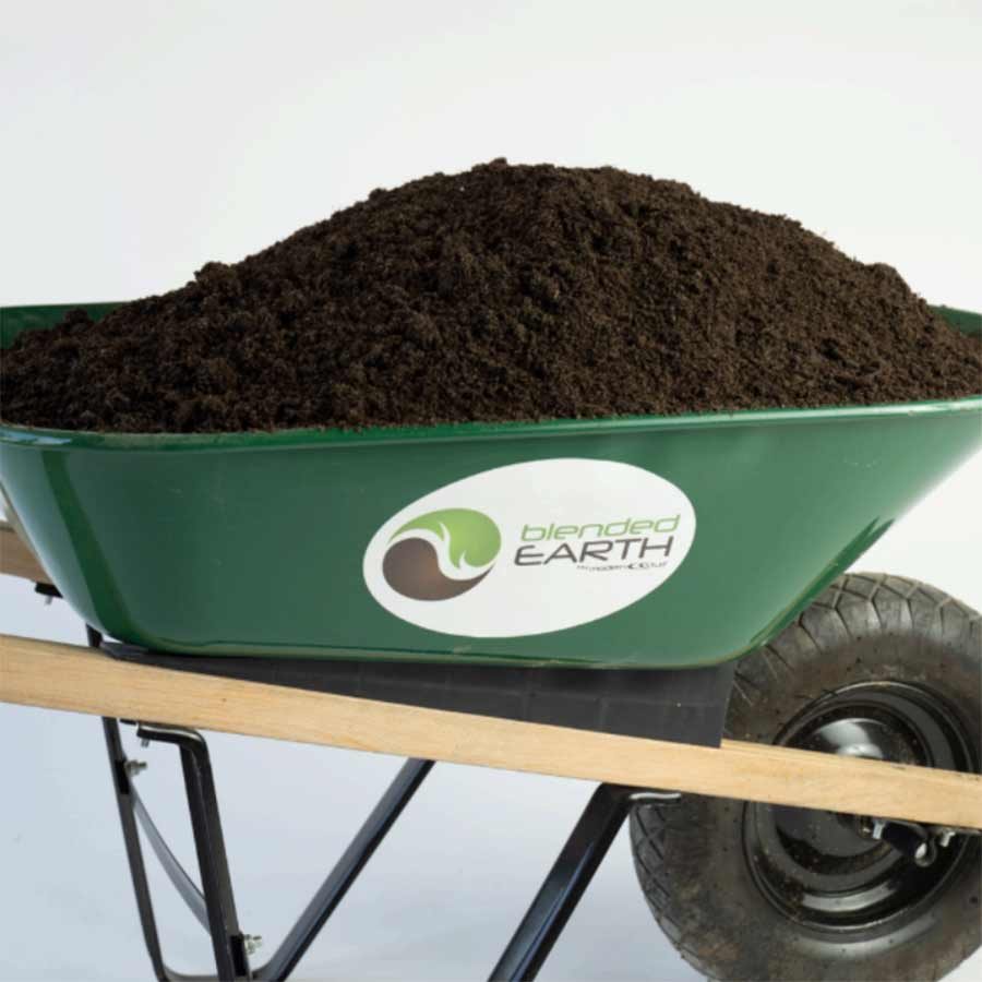 A green wheelbarrow filled with dark soil, labeled blended EARTH, on a white background.